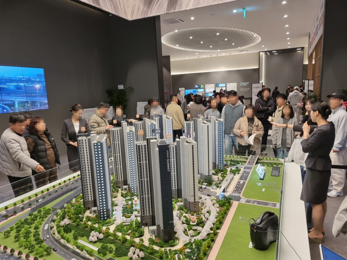 지난달 28일 경기 김포시 사우동 547-8번지에 개관한 ‘호반써밋 인천검단 3차’ 견본주택에서 방문객들이 아파트 단지 모형에 대한 설명을 듣고 있다. 호반산업 제공