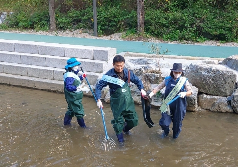 서울 송파구 ‘자원봉사자의 날’ 기념행사에서 ‘자원봉사 명문가’로 선정된 안상순씨 가족이 하천을 청소하고 있는 모습. 송파구 제공