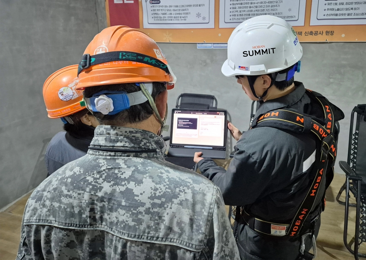 호반건설 직원이 지난달 수도권의 한 건설 현장에서 인공지능(AI) 동시 번역 플랫폼 ‘호반커넥트’를 활용해 근로자들과 대화하고 있다. 호반건설 제공