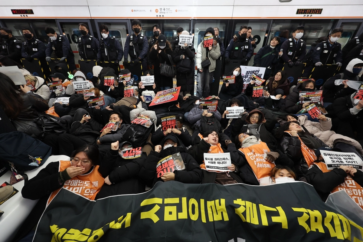 전국장애인차별철폐연대가 지난달 24일 오전 서울 종로구 안국역에서 출근길 승강장 다이인(die-in)행동을 열자 참가자들이 바닥에 눕는 퍼포먼스를 진행하고 있다. 2024.12.24. 연합뉴스