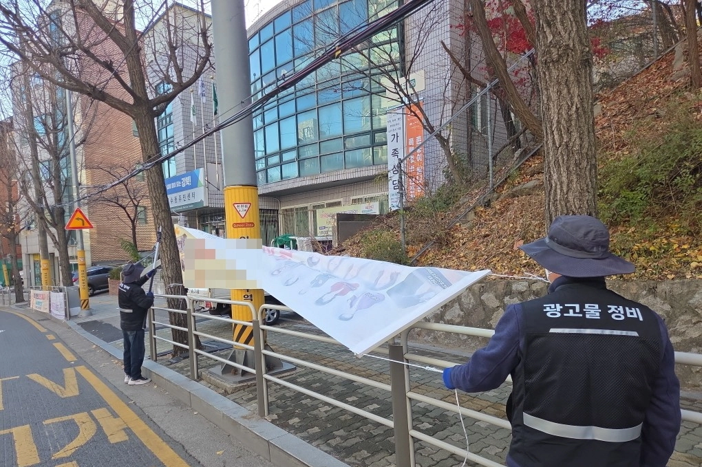 서울 강북구 금지 광고물 점검반이 불법 현수막을 정비하고 있다. 강북구 제공
