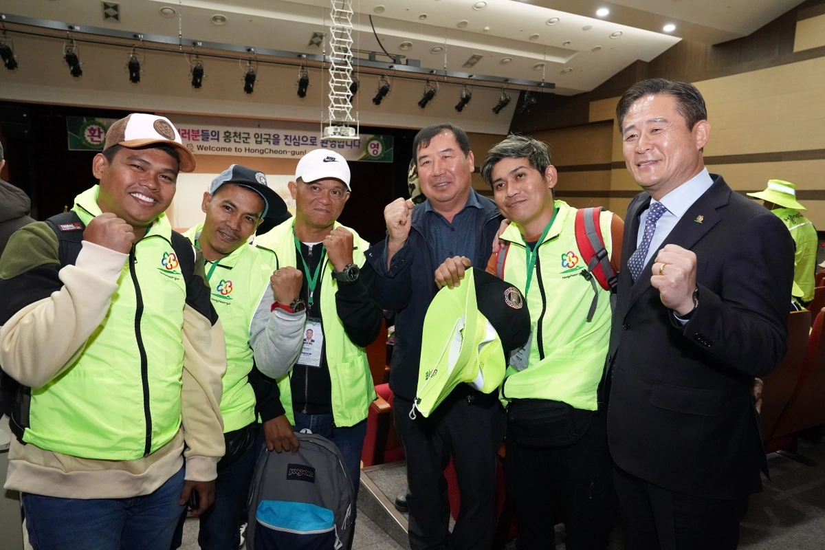 신영재(오른쪽) 군수가 지난 3월 홍천문화원에서 열린 입국설명회에서 외국인 계절근로자 등과 함께 기념사진을 찍고 있다. 홍천군 제공