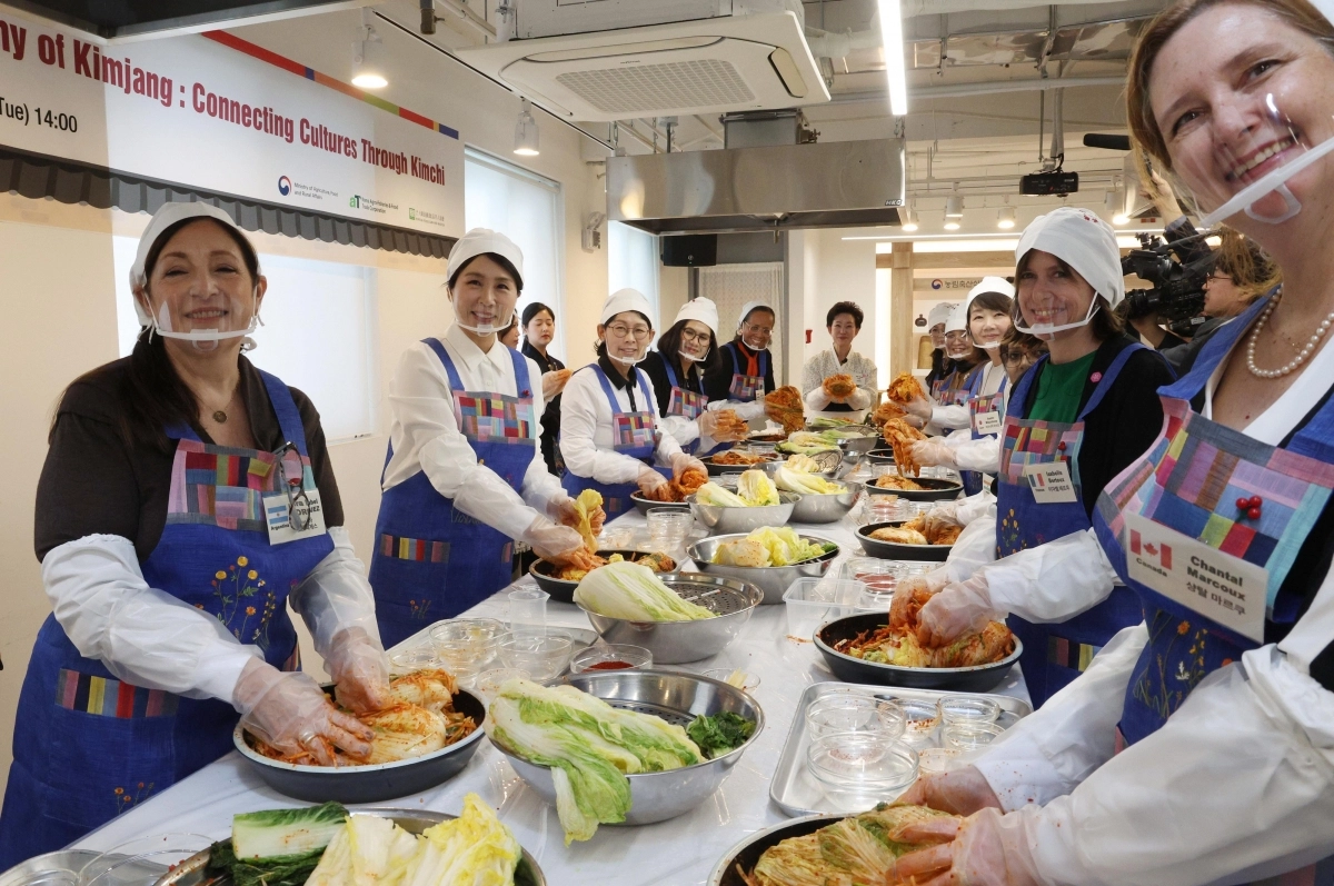 김혜경(왼쪽 두 번째) 여사가 9일 서울 종로구 북촌 한식문화공간 이음에서 열린 주한대사 배우자 초청 김장 행사에서 주한 외국대사 배우자들과 함께 김치를 버무리며 기념사진을 찍고 있다. 연합뉴스