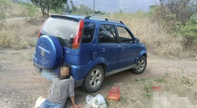 사고를 조작하기 위해 차 뒤에 기대어 있는 란씨의 모습. QQ닷컴