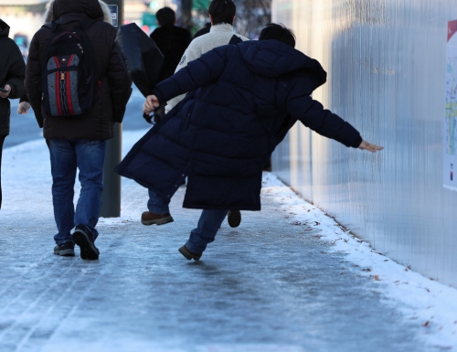 폭설 후 한파로 도로 곳곳이 얼어붙은 지난 5일 오전 서울 광화문역 일대에서 한 시민이 빙판길에 미끄러져 넘어지고 있다. 도로 살얼음은 자동차 사고뿐만 아니라 낙상 사고의 원인이기도 하다. 뉴스1