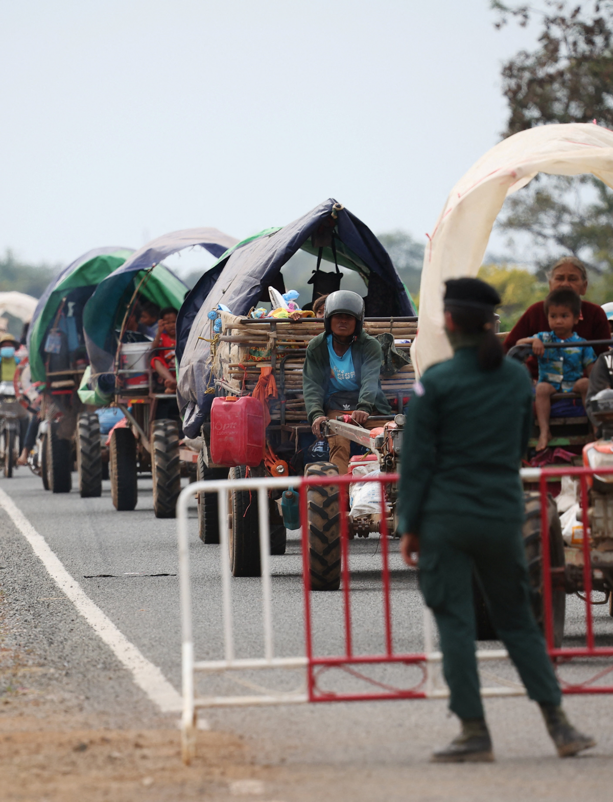 태국과 캄보디아 간의 무력 충돌을 피해 대피하는 사람들을 한 경찰관이 난민 캠프로 안내하고 있다. 오다르민체이 로이터 연합뉴스