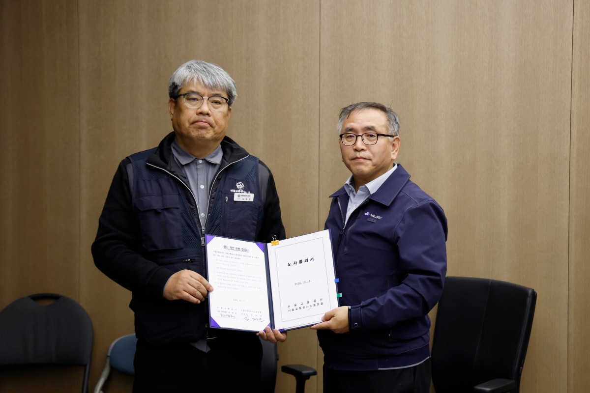 서울교통공사 노사 임금·단체협약(임단협) 협상이 타결된 뒤 김태균(왼쪽) 제1노조 위원장과 한영희 서울교통공사 기획본부장(사장 직무대행)이 노사합의서를 들고 있다.  서울교통공사 제공