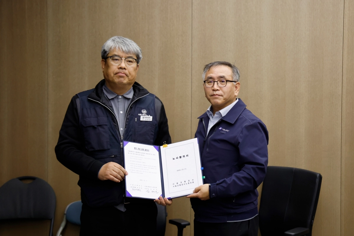 서울교통공사 노사 임금·단체협약(임단협) 협상이 타결된 뒤 김태균(왼쪽) 제1노조 위원장과 한영희 서울교통공사 기획본부장(사장 직무대행)이 노사합의서를 들고 있다.  서울교통공사 제공