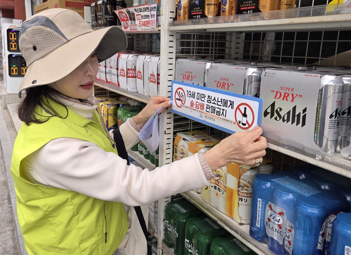 주민이 참여하는 서울 서초구의 ‘우리동네 술래잡기단’ 단원이 마트 주류 판매대에 청소년 판매 금지 캠페인 스티커를 부착하고 있다. 서초구 제공