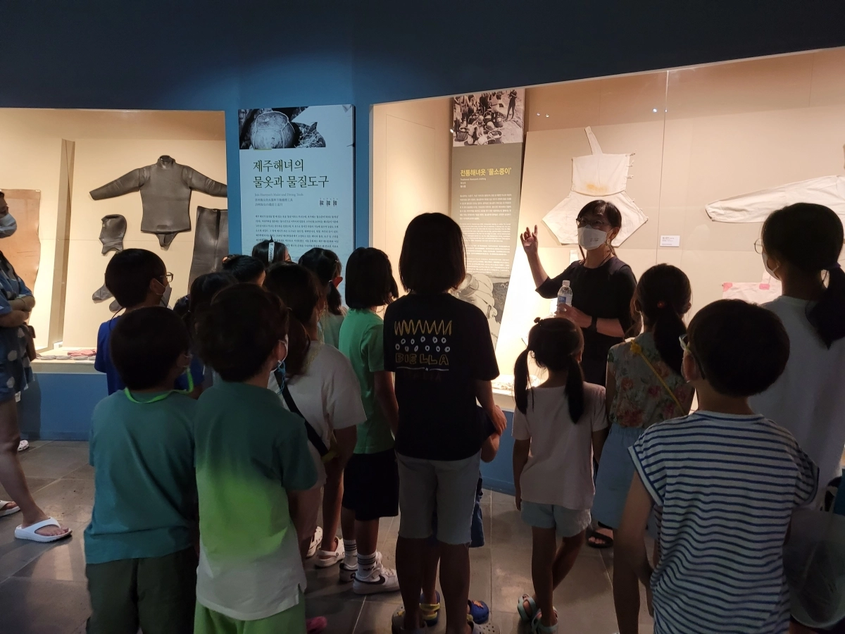 제주해녀박물관에서 제주 해녀 전통옷 물소중이 등 물질할 때 쓰는 도구들을 어린이 관람객들에게 설명하고 있다. 해녀박물관 제공