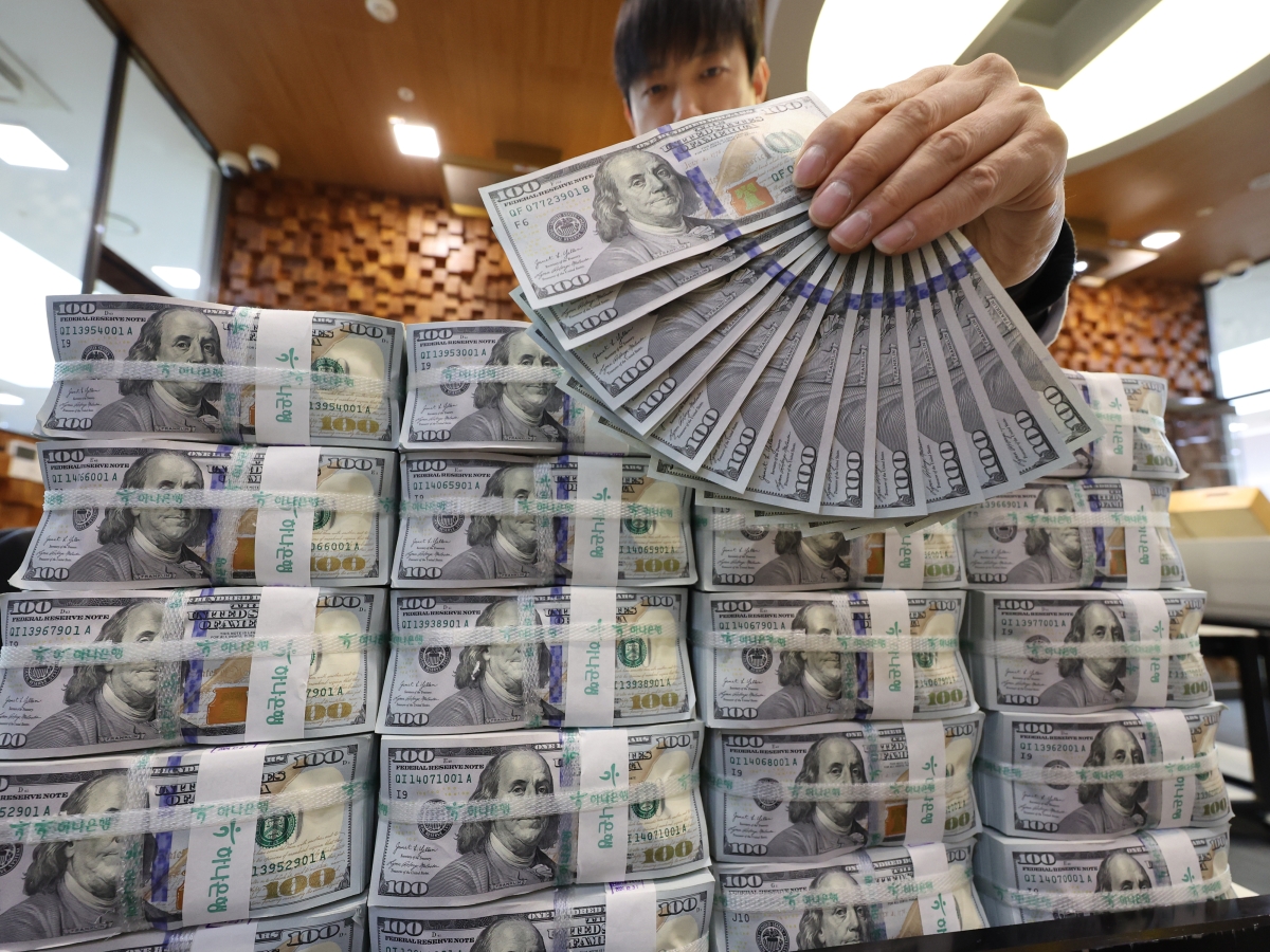 16일 서울 중구 하나은행 위변조대응센터에서 직원이 미화 100달러 뭉치를 정리하며 1300달러를 펼쳐 보이고 있다. 외환당국은 환율 안정을 위해 국민연금과 650억 달러 규모의 외환스와프 계약을 내년까지 1년 연장하기로 했다. 연합뉴스