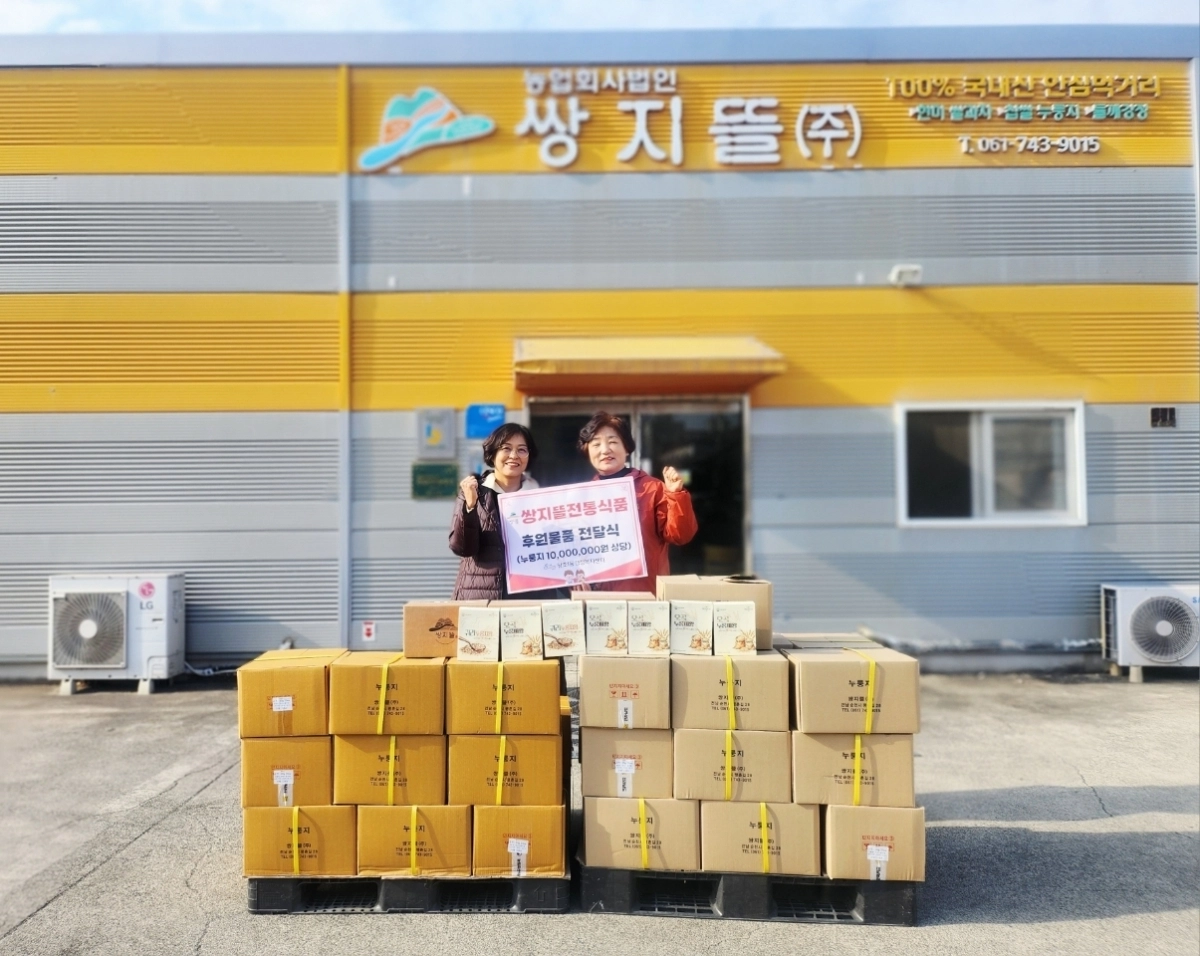 신혜정(왼쪽) 왕조1동장과 김해옥 쌍지뜰 대표가 기부물품 앞에서 기념사진을 찍고 있다.