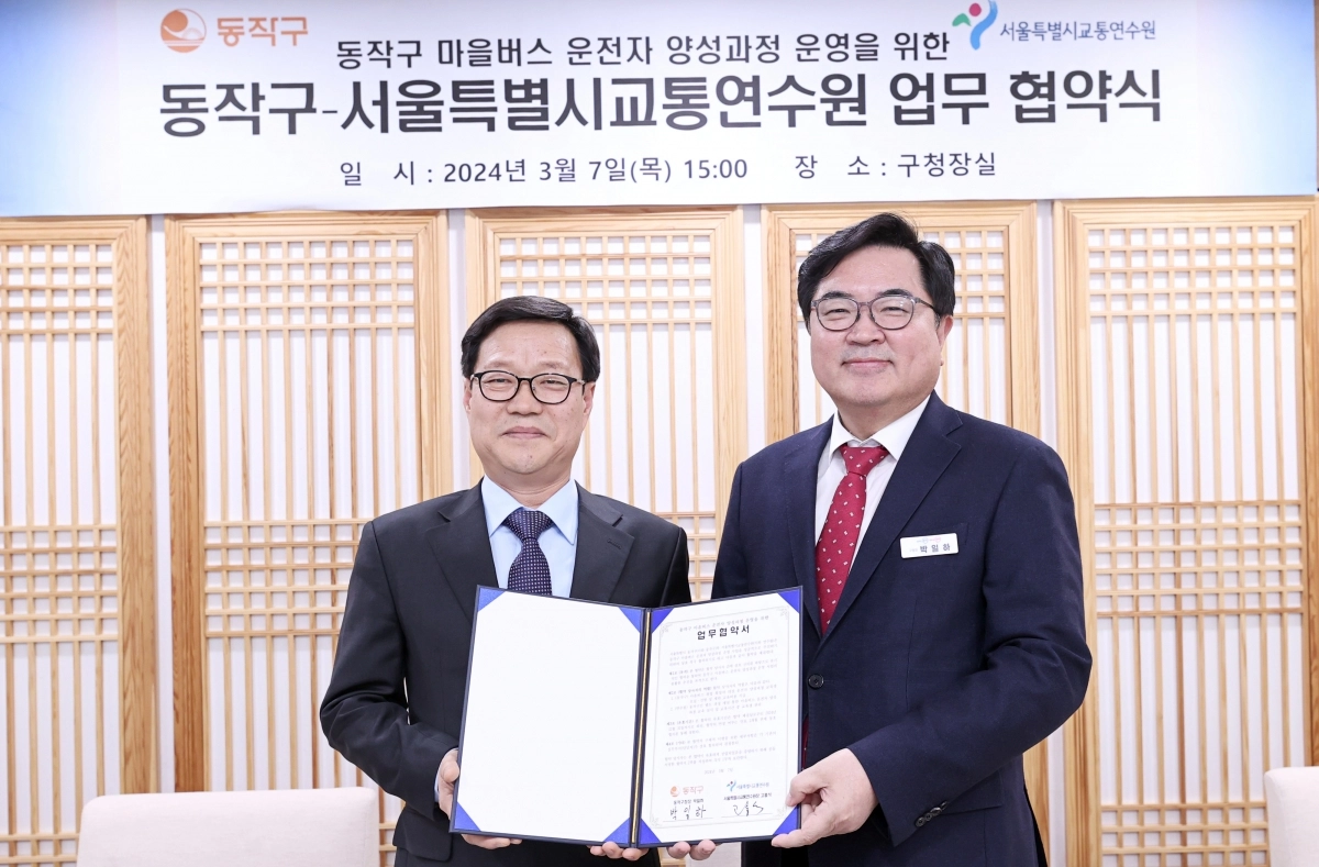 박일하(오른쪽() 동작구청장이 지난해 3월 고홍석 서울시 교통연수원장(왼쪽)과 ‘마을버스 운전자 양성과정 운영을 위한 업무협약’을 체결한 후 기념 촬영하고 있다. 동작구 제공