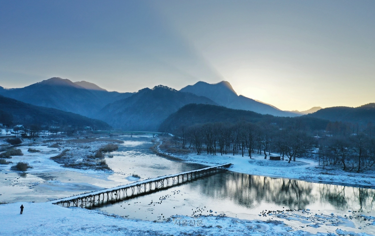 강원 영월군 판운리 섶다리 위로 첫눈이 내렸다. 섶다리는 장마철엔 철거되고 갈수기에 새로 놓이는 나무다리다. 침식과 퇴적이 반복되며 생긴 사행천(蛇行川)이 많은 영월, 정선 등에서 볼 수 있다.