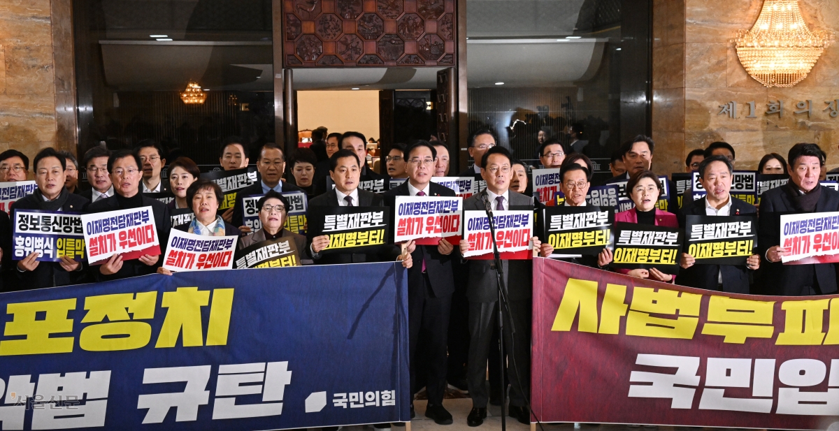 송언석(앞줄 왼쪽 여섯 번째) 원내대표를 비롯한 국민의힘 의원들이 22일 국회 본회의 직전 로텐더홀에서 규탄대회를 열고 여당의 내란전담재판부 설치법 상정에 항의하는 구호를 외치고 있다. 안주영 전문기자