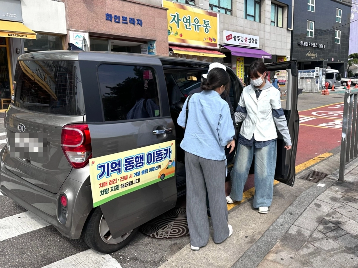 구로구 관계자가 지난 10월 ‘기억동행 이동카’에서 내리는 어르신을 돕고 있다. 구로구 제공