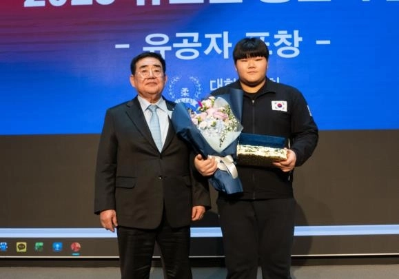 유도 여자 국가대표 이현지(오른쪽)가 22일 서울 송파구 올림픽파크텔에서 2025 유도인 송년의 밤 행사에서 최우수선수상을 받은 뒤 포즈를 취하고 있다. 왼쪽은 조용철 대한유도회장. 대한유도회 제공