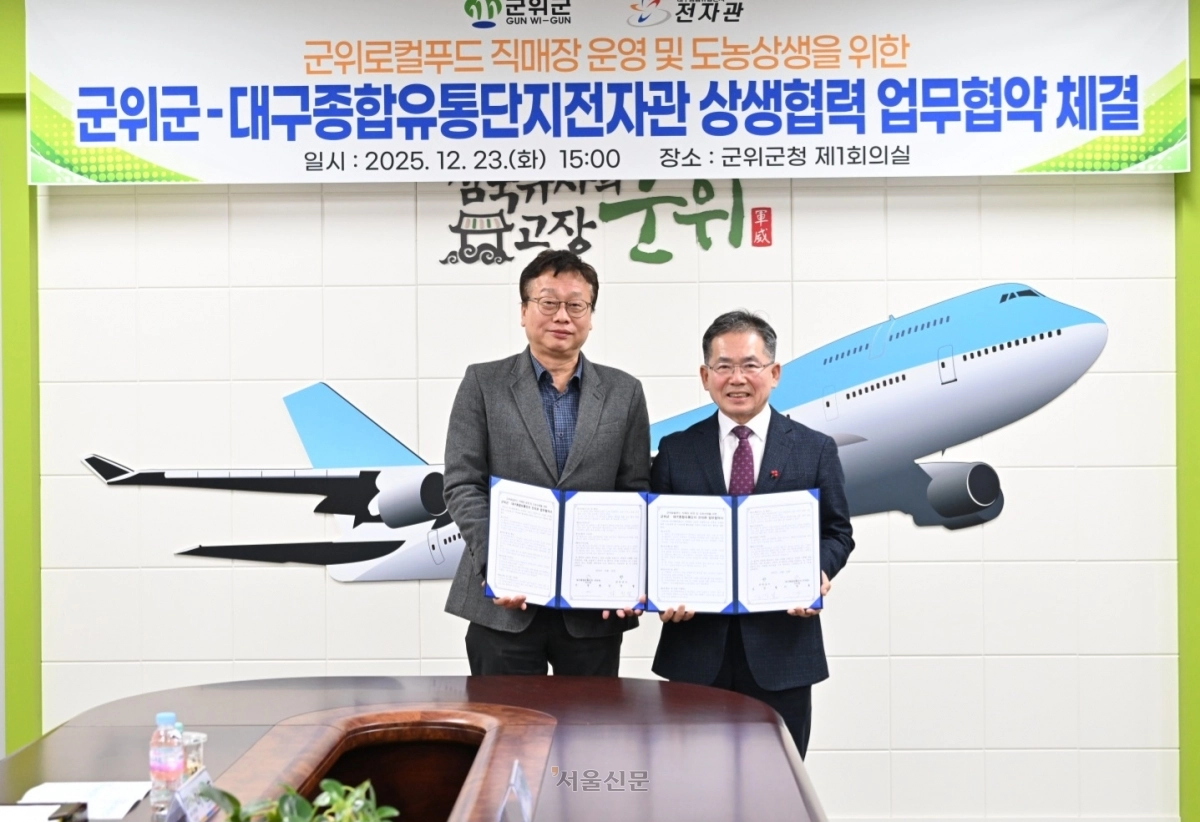 김진열(오른쪽) 대구 군위군수가 23일 군청에서 대구종합유통단지전자관과 군위로컬푸드직매장 운영을 위한 업무협약 체결 후 기념사진을 찍고 있다.