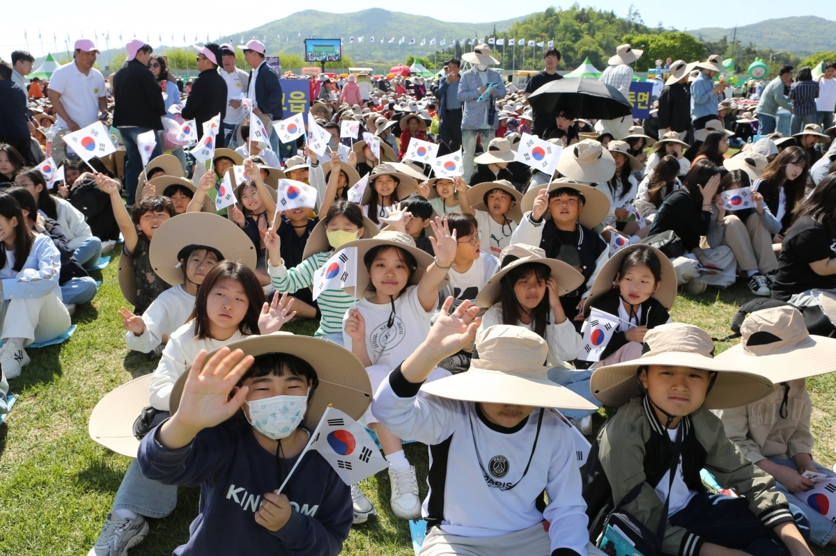 2025년 통합대축제  행사에 참가한 아이들이 손을 흔들고 있다.