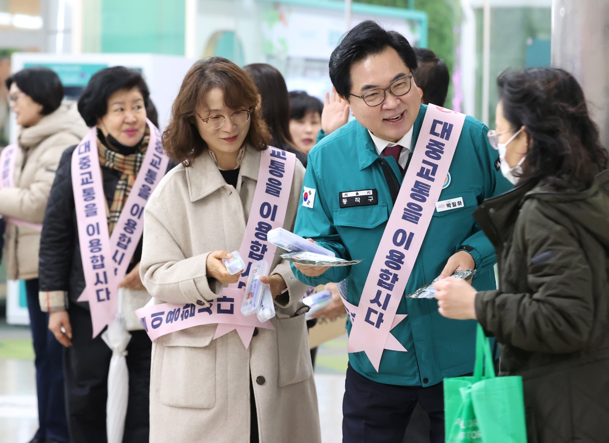 박일하(오른쪽 두번재) 동작구청장이 지난 11월 ‘서울교통 Re-디자인’ 캠페인에서 시민들에게 대중교통 이용을 독려하는 홍보물을 나눠주고 있다. 동작구 제공