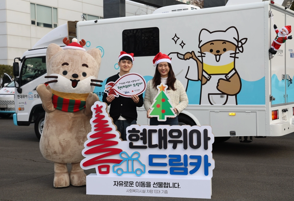 현대위아 직원들이 지난 23일 경남 창원시 현대위아 본사 앞에서 지역 사회복지기관 10곳에 선물할 ‘현대위아 드림카’와 함께 기념 촬영을 하고 있다.  현대위아 제공