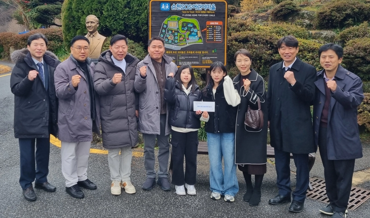 김정희 전남도의회 교육위원장과 순천용당초등학교 교직원, 학부모 대표, 학생 대표 등이 순천 SOS 어린이마을에 기부금을 전달하고 기념촬영을 하고 있다.