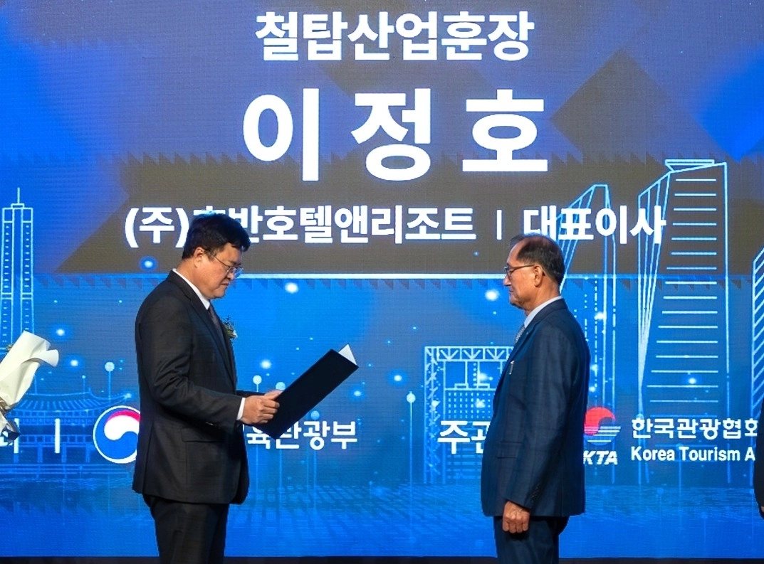 이정호(오른쪽) 호반호텔앤리조트 부회장(대표이사)이 김대현(왼쪽) 문화체육관광부 제2차관에게 철탑산업훈장을 받고 있다. 호반호텔앤리조트 제공