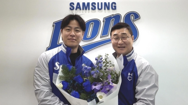 프로야구 최고령 포수 강민호(왼쪽)가 28일 대구삼성라이온즈파크에서 원소속팀 삼성 라이온즈와 2년 총액 20억원에 계약한 뒤 이종열 단장과 기념사진을 찍고 있다.﻿  삼성 라이온즈 제공