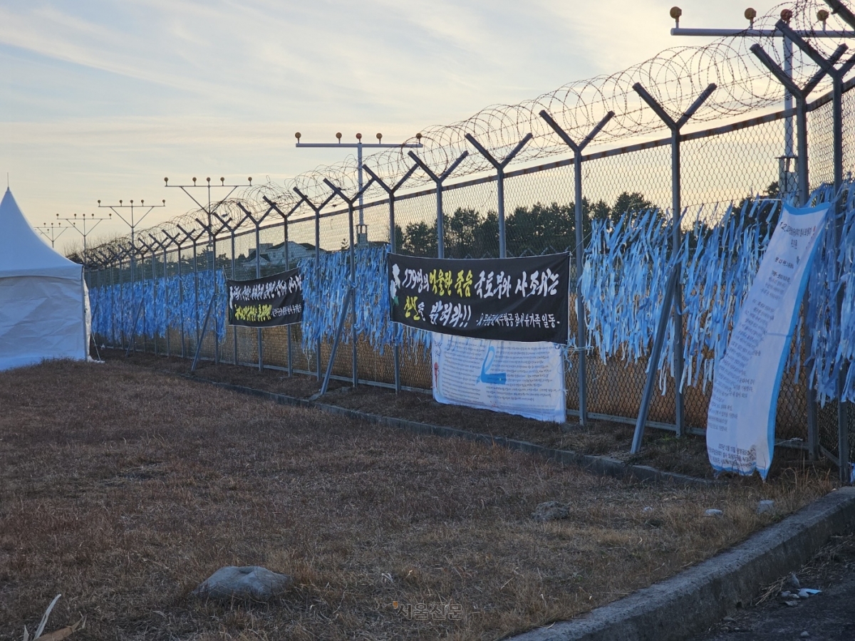 무안공항 곳곳 철제 펜스에는 희생자들이 하늘을 훨훨 날아가라는 의미가 깃든 푸른색 리본 수천개가 걸려 있다.