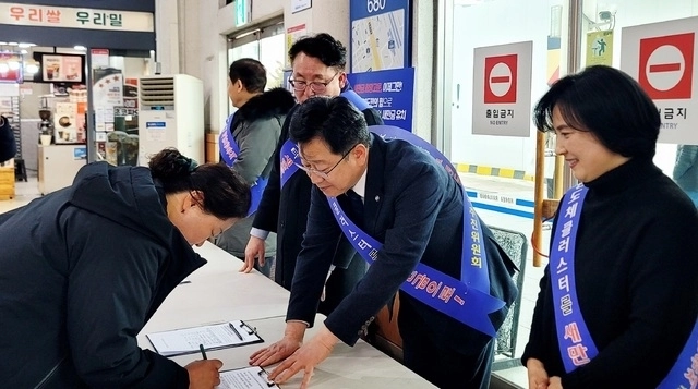 안호영(가운데) 더불어민주당 의원과 반도체클러스터 새만금 유치추진위원회가 지난해 12월 29일 전주역에서 서명운동을 하고 있다. 반도체클러스터 새만금 유치추진위원회 제공