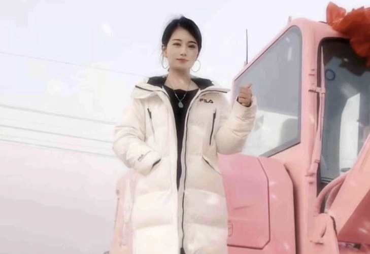 분홍색 굴착기 위에서 포즈를 취하고 있는 장씨. 더우인 캡처