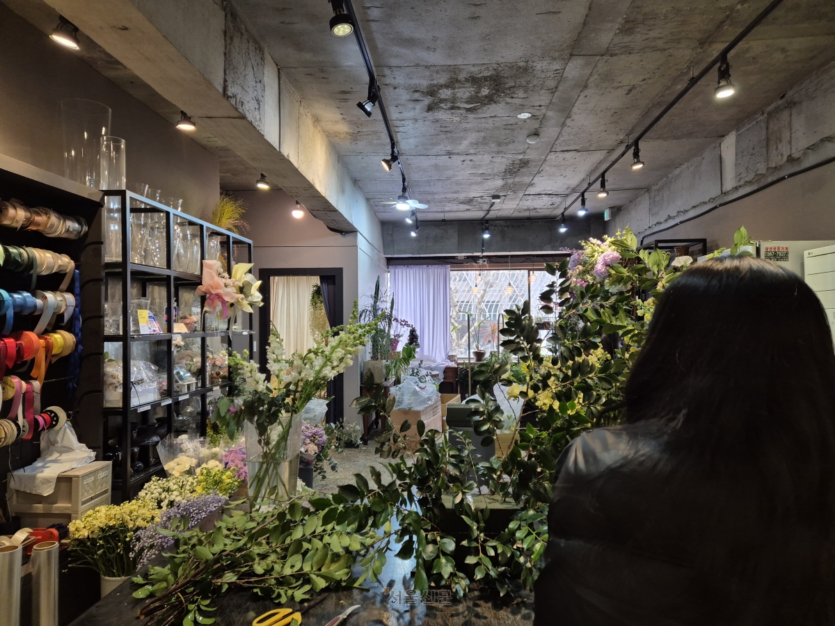 지난달 27일 서울 강남구에서 웨딩 전문 꽃집을 운영하는 최혜란(뒷모습)씨가 이튿날 결혼식장에 놓일 꽃 장식을 만들고 있다.  반영윤 기자