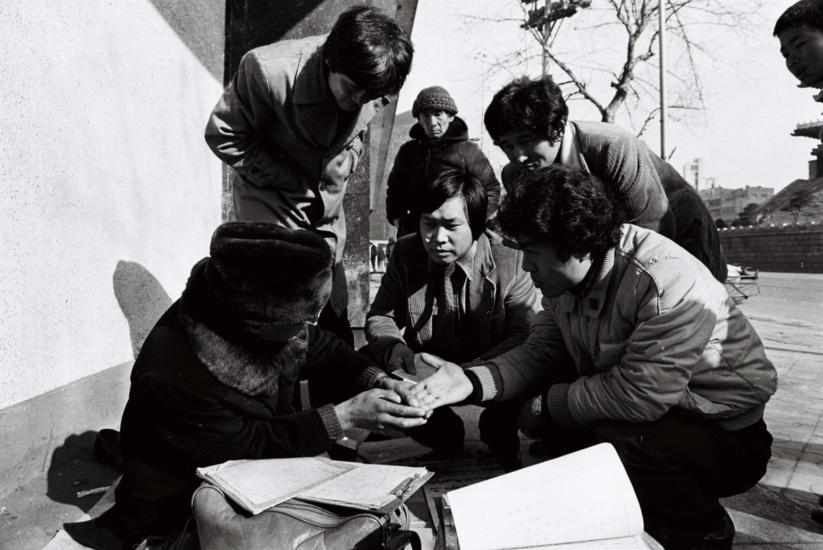 1982년 새해를 맞아 서울 중심가 대로변에서 행인들이 점사로부터 손금과 토정비결을 보고 있다. 서울신문 DB