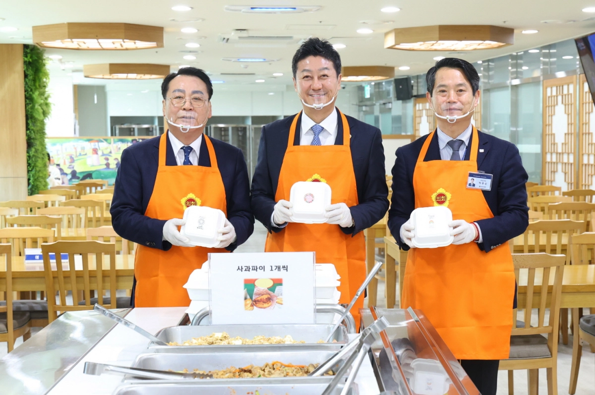 김진경 의장(가운데)이 2일 새해맞이 의회사무처 직원 격려 오찬에서 임채호 의회사무처장(왼쪽), 박호순 의정국장과 함께 직원들에게 나눠줄 사과파이를 들고 기념촬영을 하고 있다.(사진=경기도의회)