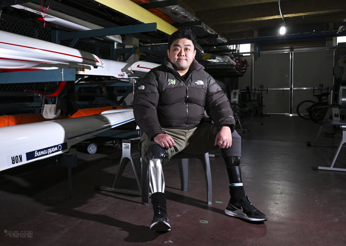 서울주택도시개발공사(SH) 장애인조정팀의 하재헌 선수가 지난해 12월 30일 경기 하남 미사리조정경기장에 보관된 조정 장비 옆에 바지를 걷어 올리고 앉았다. 2015년 목함지뢰 사고로 두 다리를 잃은 그는 24차례의 수술과 지난한 재활을 딛고 조정 선수로 인생 2막을 살고 있다. 이지훈 기자