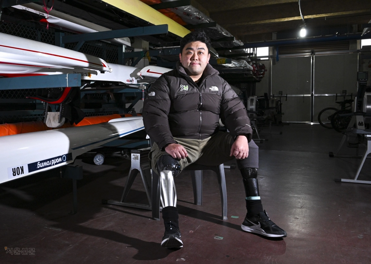 서울주택도시개발공사(SH) 장애인조정팀의 하재헌 선수가 지난해 12월 30일 경기 하남 미사리조정경기장에 보관된 조정 장비 옆에 바지를 걷어 올리고 앉았다. 2015년 목함지뢰 사고로 두 다리를 잃은 그는 24차례의 수술과 지난한 재활을 딛고 조정 선수로 인생 2막을 살고 있다. 이지훈 기자