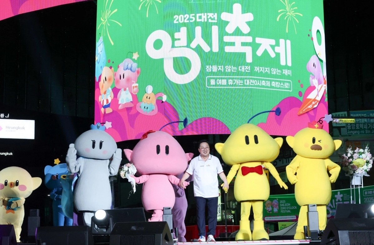 이장우 시장이 지난해 8월 열린 ‘대전 영시 축제’ 당시 대전을 상징하는 캐릭터 꿈돌이와 꿈순이의 손을 잡고 중앙로 특설무대에 입장하고 있다.  대전시 제공