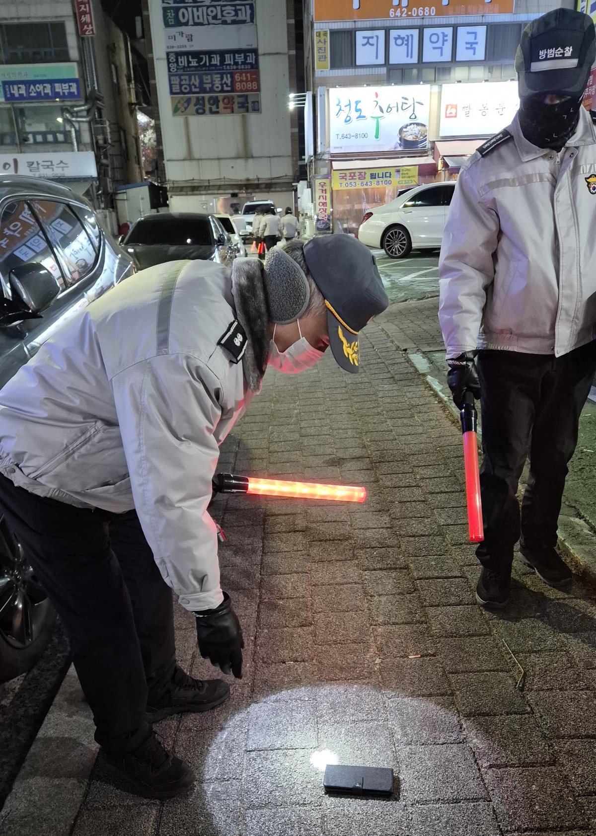 도원동 자율방범대원들이 순찰 중 길거리에 떨어져 있던 휴대 전화를  회수하고 있다. 휴대 전화는 주인에게 돌려주기 위해 인근 파출소에 전달했다. 사진: 도원동 자율방범대 제공.