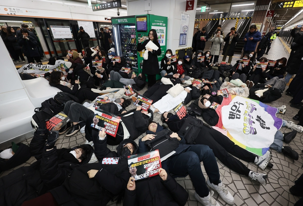 전국장애인차별철폐연대가 지난해 12월 24일 오전 서울 종로구 안국역에서 출근길 승강장 다이인(die-in)행동을 열자 참가자들이 바닥에 눕는 퍼포먼스를 진행하고 있다. 2024.12.24. 연합뉴스