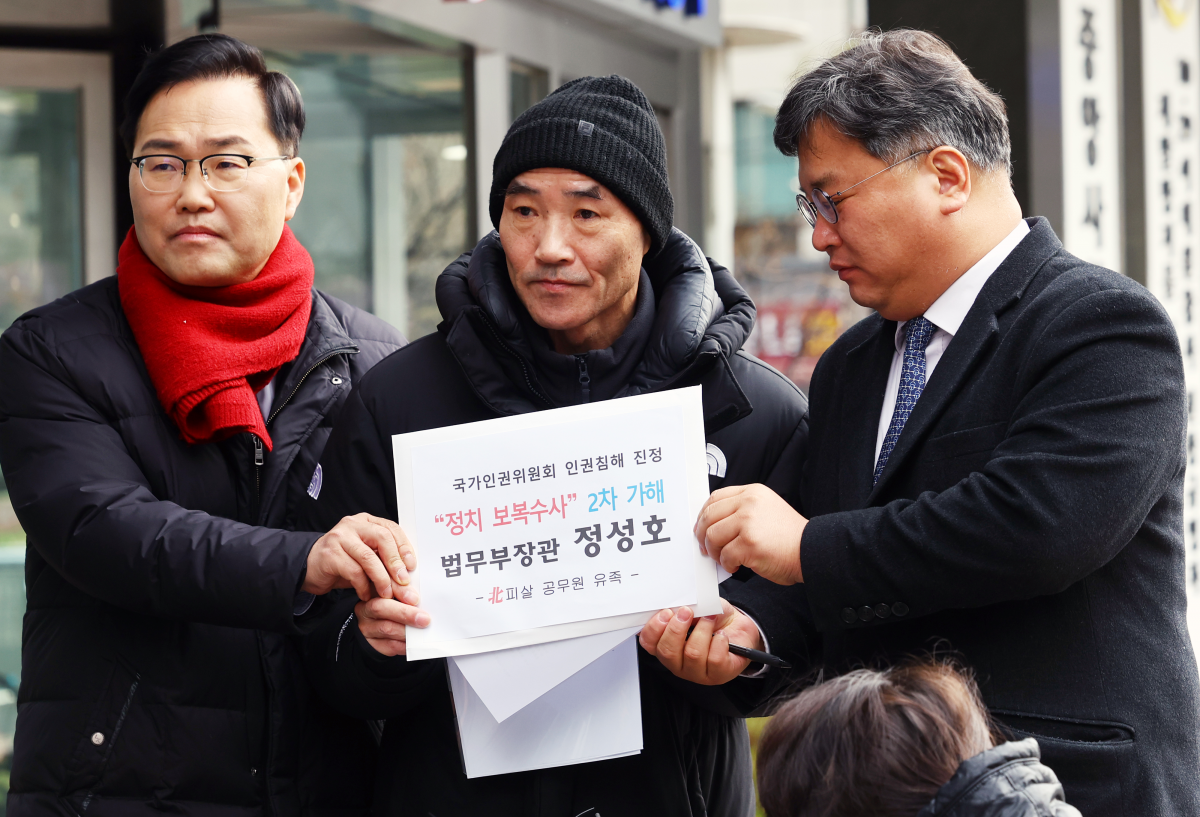 서해 피격 공무원 유족 이래진(가운데)씨가 김기윤 변호사(오른쪽), 송석준 국민의힘 의원과 6일 서울 중구 국가인권위원회 앞에서 정성호 법무부장관에 대한  진정 기자회견을 하고 있다. /뉴시스