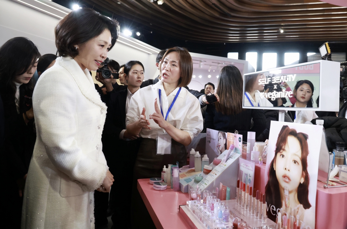 이재명 대통령과 중국을 국민 방문한 김혜경 여사가 7일 상하이 푸싱예술센터에서 열린 K뷰티 행사장에서 한 부스 관계자의 설명을 듣고 있다. 2026.1.7 연합뉴스