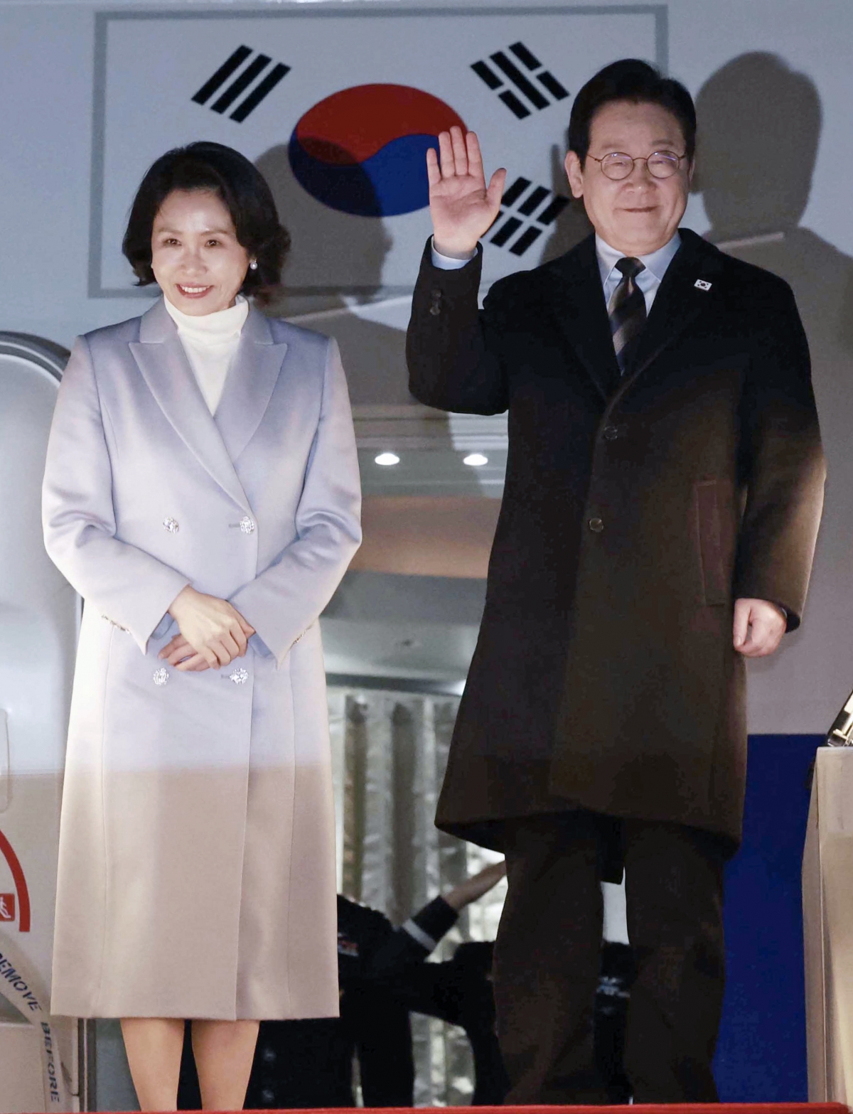 중국 국빈 방문 공식 일정을 마친 이재명 대통령과 김혜경 여사가 7일 상하이 푸둥공항 한국행 공군 1호기에서 환송객에게 인사하고 있다. 2026.1.7 연합뉴스
