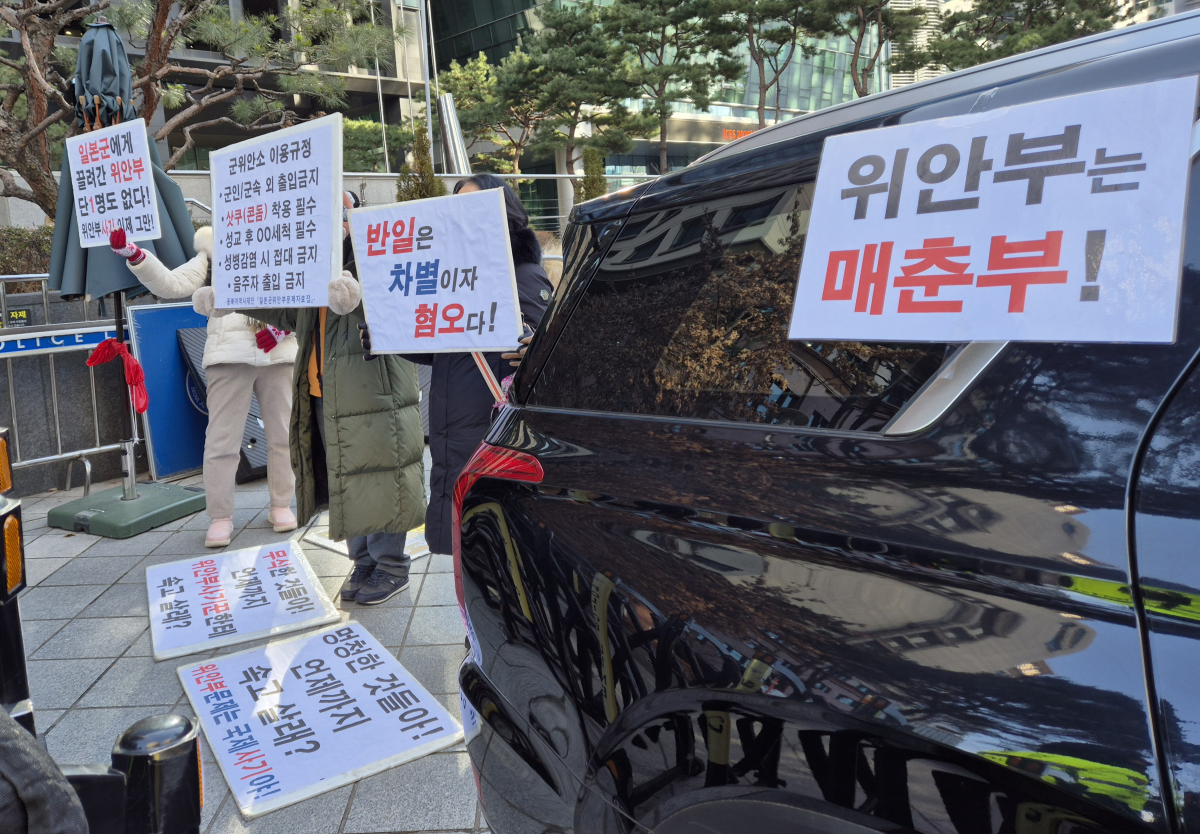 지난 7일 서울 종로구 옛 주한 일본대사관 인근 평화의소녀상 옆에서 극우 성향의 시민단체 ‘위안부법폐지국민행동’ 회원들이 위안부 피해자들을 모욕하는 피켓을 들고 있다. 반영윤 기자