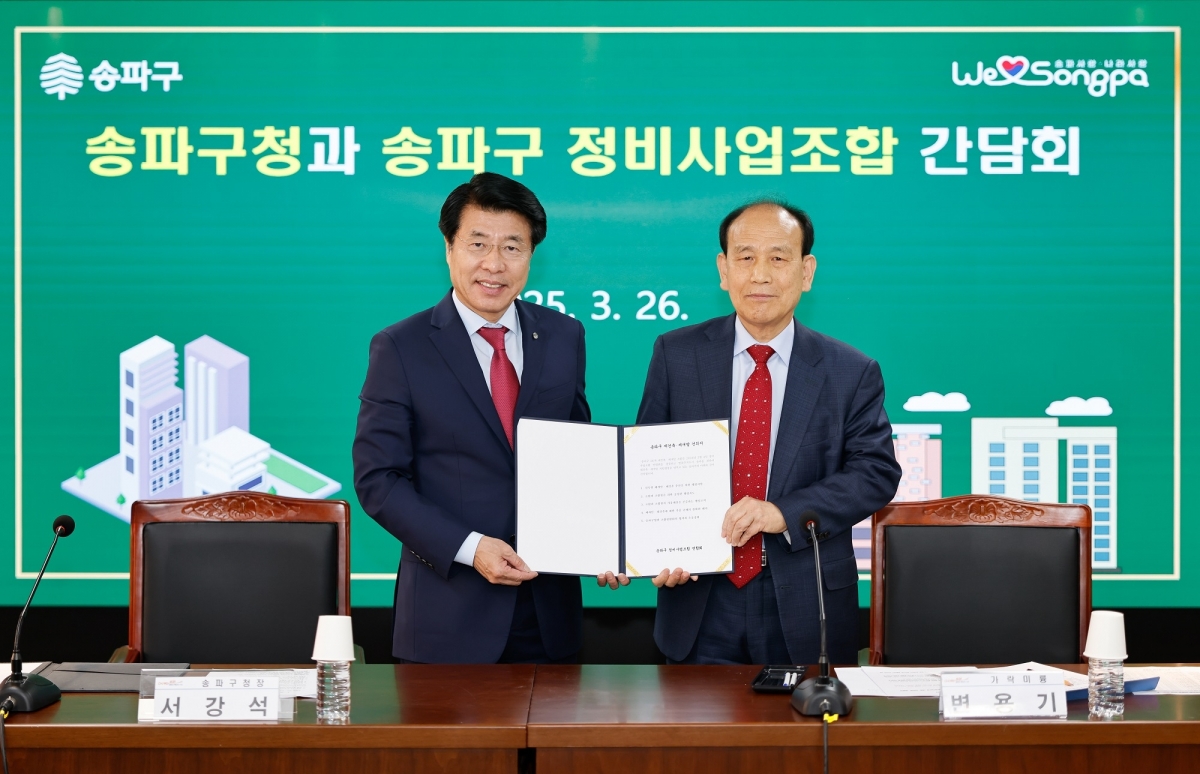 서강석(왼쪽) 송파구청장이 지난해 3월 변용기 송파구 정비사업조합 연합회장과 함께 재건축 건의서를 든 채 기념촬영을 하고 있다.  송파구 제공