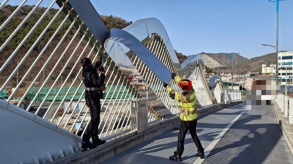 강풍으로 경남 창원시 진해구 용원동에 있는 한 다리 구조물이 떨어지면서 소방당국이 안전 조치를 하고 있다. 2026.1.11. 창원소방본부 제공