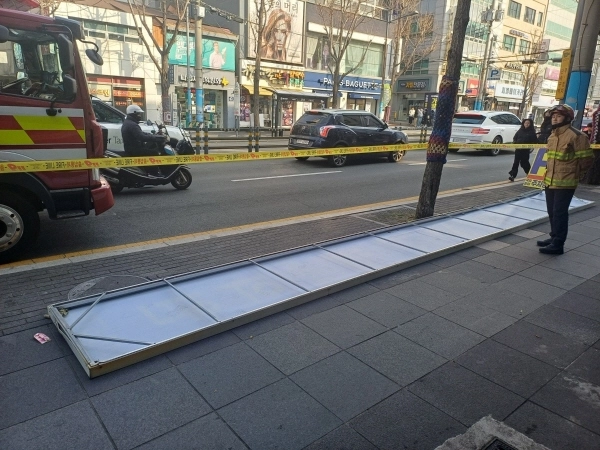 인도에 떨어진 간판. 2026.1.11. 부산소방본부 제공