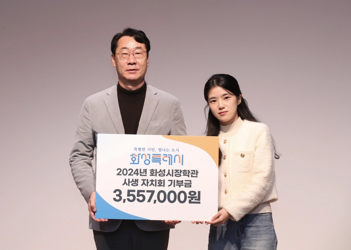 정명근 화성특례시장이 2025년 화성시장학관 입사식에서 사생 자치회 기부금을 전달받고 있다. (화성시 제공)