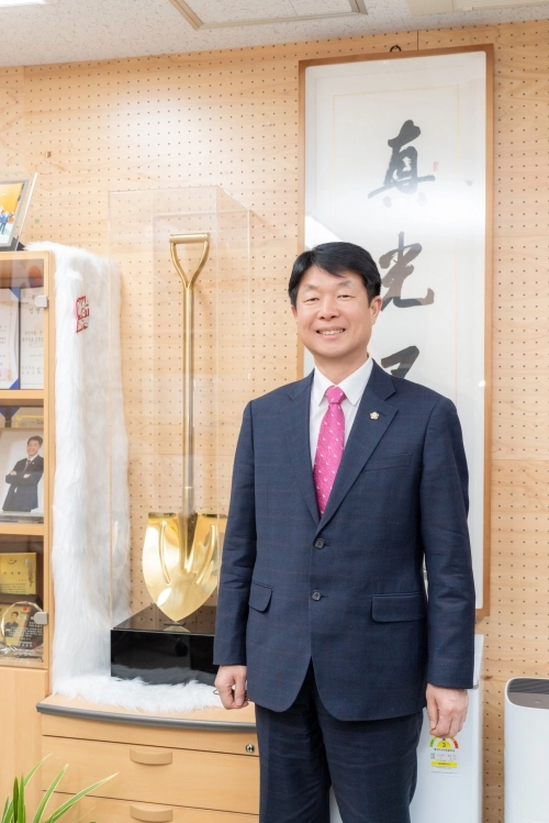 이성수 서울 강남구의원이 지난 9일 주민들이 선물한 ‘금빛 삽’ 앞에서 포즈를 취하고 있다. 강남구의회 제공