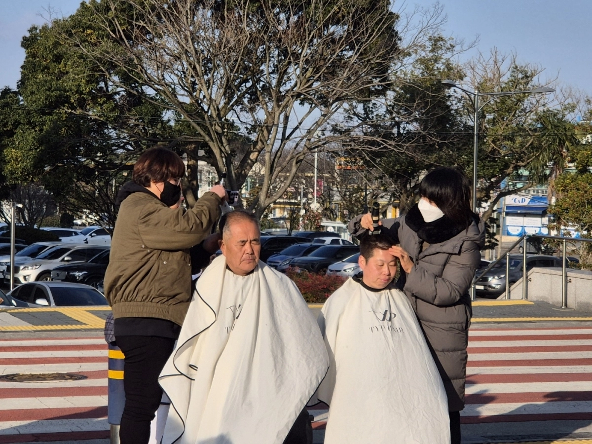 13일 오전 제주대학교 정문 앞에서 동문과 재학생이 미래융합대학교수 계약 만료를 둘러싸고 삭발을 단행하고 있다. 미래융합대학 교수진 제공