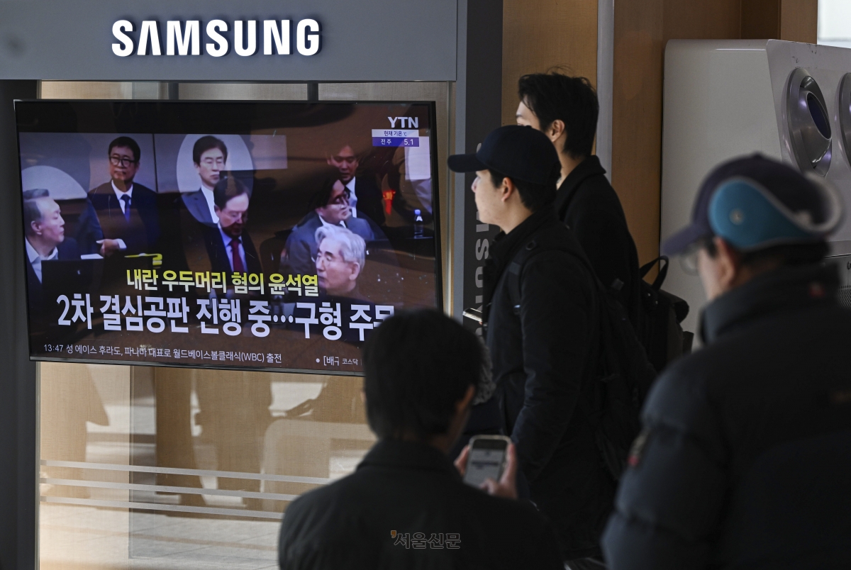 윤석열 내란 우두머리 혐의 2차 결심공판이 열린 13일 서울역 대합실에서 시민들이 관련 뉴스를 시청하고 있다. 이지훈 기자